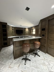 Interior of Llyod Harbor Residence, completed in 2024, featuring custom millwork in the bar area, state-of-the-art cinema room, and stylish game room, located in Long Island, NY