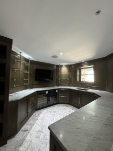 Interior of Llyod Harbor Residence, completed in 2024, featuring custom millwork in the bar area, state-of-the-art cinema room, and stylish game room, located in Long Island, NY