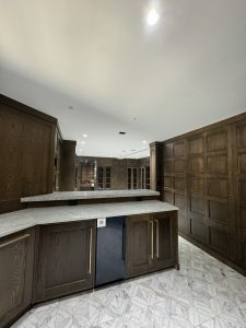 Interior of Llyod Harbor Residence, completed in 2024, featuring custom millwork in the bar area, state-of-the-art cinema room, and stylish game room, located in Long Island, NY