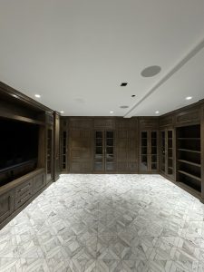 Interior of Llyod Harbor Residence, completed in 2024, featuring custom millwork in the bar area, state-of-the-art cinema room, and stylish game room, located in Long Island, NY