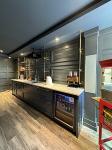 Interior of Llyod Harbor Residence, completed in 2024, featuring custom millwork in the bar area, state-of-the-art cinema room, and stylish game room, located in Long Island, NY