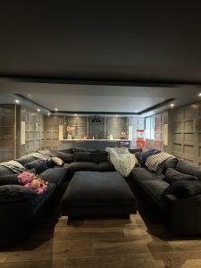 Interior of Llyod Harbor Residence, completed in 2024, featuring custom millwork in the bar area, state-of-the-art cinema room, and stylish game room, located in Long Island, NY