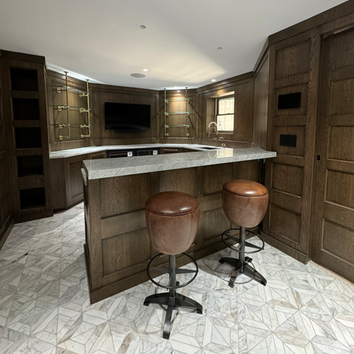 Interior of Llyod Harbor Residence, completed in 2024, featuring custom millwork in the bar area, state-of-the-art cinema room, and stylish game room, located in Long Island, NY.